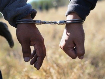 Immigrants walk handcuffed after illegally crossing the U.S.-Mexico border and being caugh