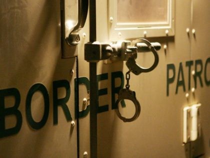 Handcuffs secure the back door of a US Customs and Border Protection border patrol vehicle