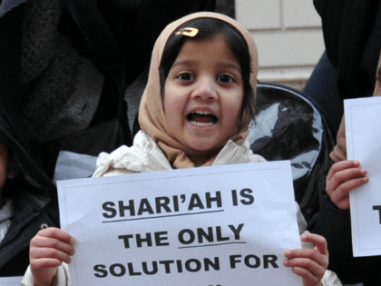Veiled Muslim women and children hold up signs reading 'Jihad' and calling for S