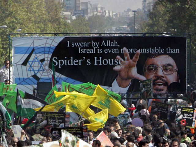 Iranian protestors, holding up a huge banner with the picture of Lebanon's Hezbollah leader Hassan Nasrallah and waving yellow flags of the Shiite Muslim guerrilla group, take part in a demonstration held in Tehran to mark Jerusalem (Al-Quds) Day, 20 October 2006. Iranian President Mahmoud Ahmadinejad said in a speech during the weekly Friday prayer today that Israel would not survive and that its allies would face the 'boiling wrath' of the people if they continued to support the Jewish state. An initiative started by Iranian revolutionary leader Ayatollah Ruhollah Khomeini, Al-Quds Day is held annually on the last Friday of the Muslim fasting month of Ramadan and calls for Jerusalem to be returned to the Palestinians. AFP PHOTO/BEHROUZ MEHRI (Photo credit should read BEHROUZ MEHRI/AFP/Getty Images)
