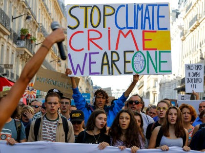 French activist Jean-Baptiste Redde, aka Voltuan, holds a placard reading 'Stop climate cr