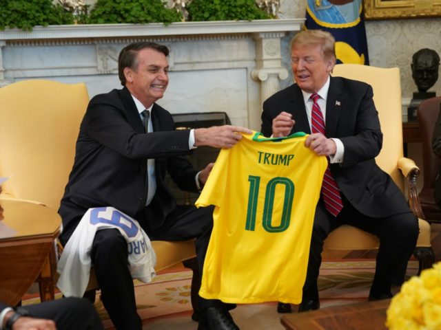Brazilian President Jair Bolsonaro presents U.S. President Donald Trump with a Brazil nati