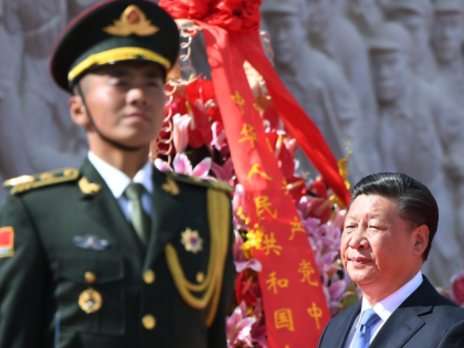 Chinese President Xi Jinping walks past a soldier after laying a wreath at the Monument to