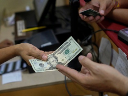 CARACAS, VENEZUELA - JUNE 26: A customer pays with a twenty US dollar bill at a bakery sho