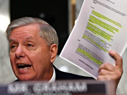 Senate Judiciary Committee Chairman Lindsey Graham, R-S.C., holds up a copy of the "Steele