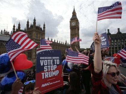 Activists wave US flags as they ride on a "Stop Trump" battle bus as they approa