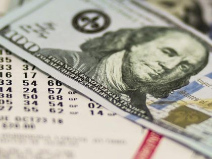 Lotto tickets are covered with one hyndred dollar bills.