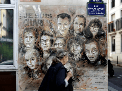 TOPSHOT - A woman walks past a painting by French street artist and painter Christian Guem