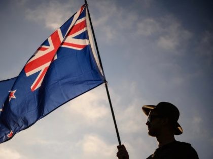 A man raises a New Zealand flag as he attends a vigil in memory of the twin mosque massacr