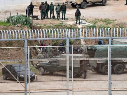 Moroccan security forces surround migrants who were planning on breaching the border fence