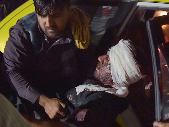 TOPSHOT - Medical and hospital staff carry an injured man out of a car for treatment after two blasts, which killed at least five and wounded a dozen, outside the airport in Kabul on August 26, 2021. (Photo by Wakil KOHSAR / AFP) (Photo by WAKIL KOHSAR/AFP via Getty Images)