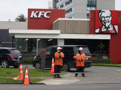 AUCKLAND, NEW ZEALAND - SEPTEMBER 22: Traffic management workers direct a large queue of c