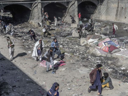 This picture taken on October 16, 2021 shows drug addicts running as Taliban members try t