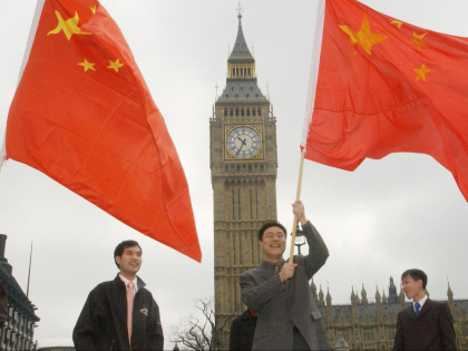 Supporters of the Chinese Government await the arrival of Prime Minister Wen Jiabao outsid