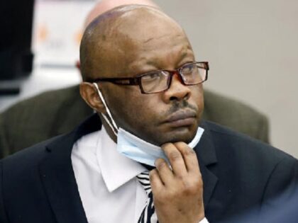Defendant Billy Chemirmir lowers his mask as a state witness is asked to identify him duri