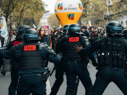 Riot police face the union procession after black bloc activists took refuge there during