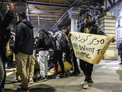 PARIS, FRANCE - JANUARY 11: A refugee holds a banner while taking shelter from the cold at