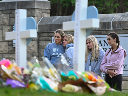 Students at a nearby school pay respects at a memorial for the people who were killed, at