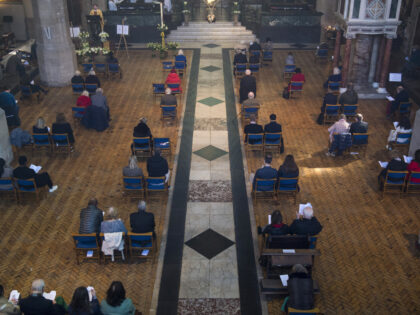 Members of the congregation social distance during the Easter Sunday service at the Holy T
