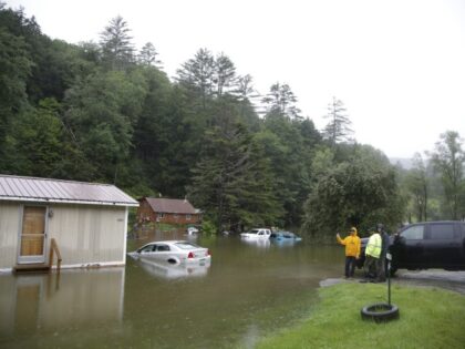 People check on a flooded home in Bridgewater, Vt., on Monday, July 10, 2023. Heavy rain d
