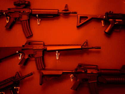 Numerous Assault Rifles Hanging On Wall. - stock photo