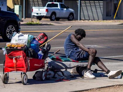 A homeless man is slumped over on a city bench in Phoenix on April 16, 2024 in Phoenix, Ar
