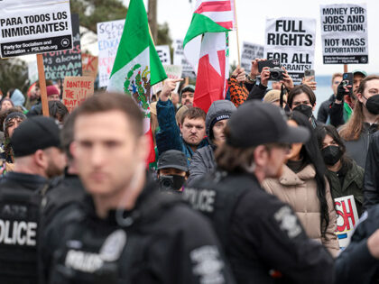 A person gives the middle finger as demonstrators react after Seattle Police officers made