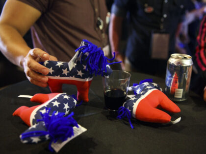 An attendee holds a donkey stuffed animal over a glass of wine during a 2016 U.S. presiden