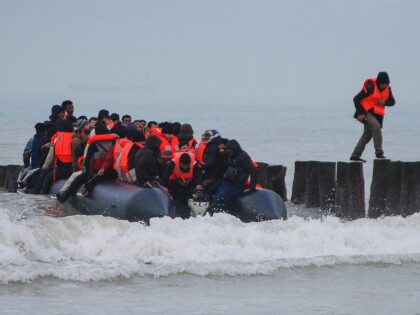 A migrant (R) returns to shore after attempting to cross the English Channel to reach Grea