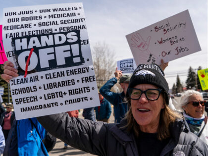 GUNNISON, CO - April 5 : A woman holds up a poster during a Hands Off protest in Gunnison,
