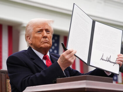 U.S. President Donald Trump displays a signed executive order imposing tariffs on imported