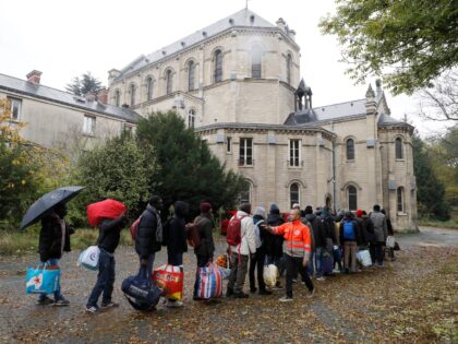 TOPSHOT - A volunteer of the Red Cross (C) counts migrants and refugees as they arrive to